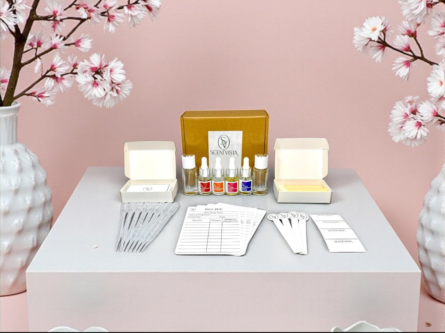 Cosmetic set on a table with cherry blossom branches against a pink background
