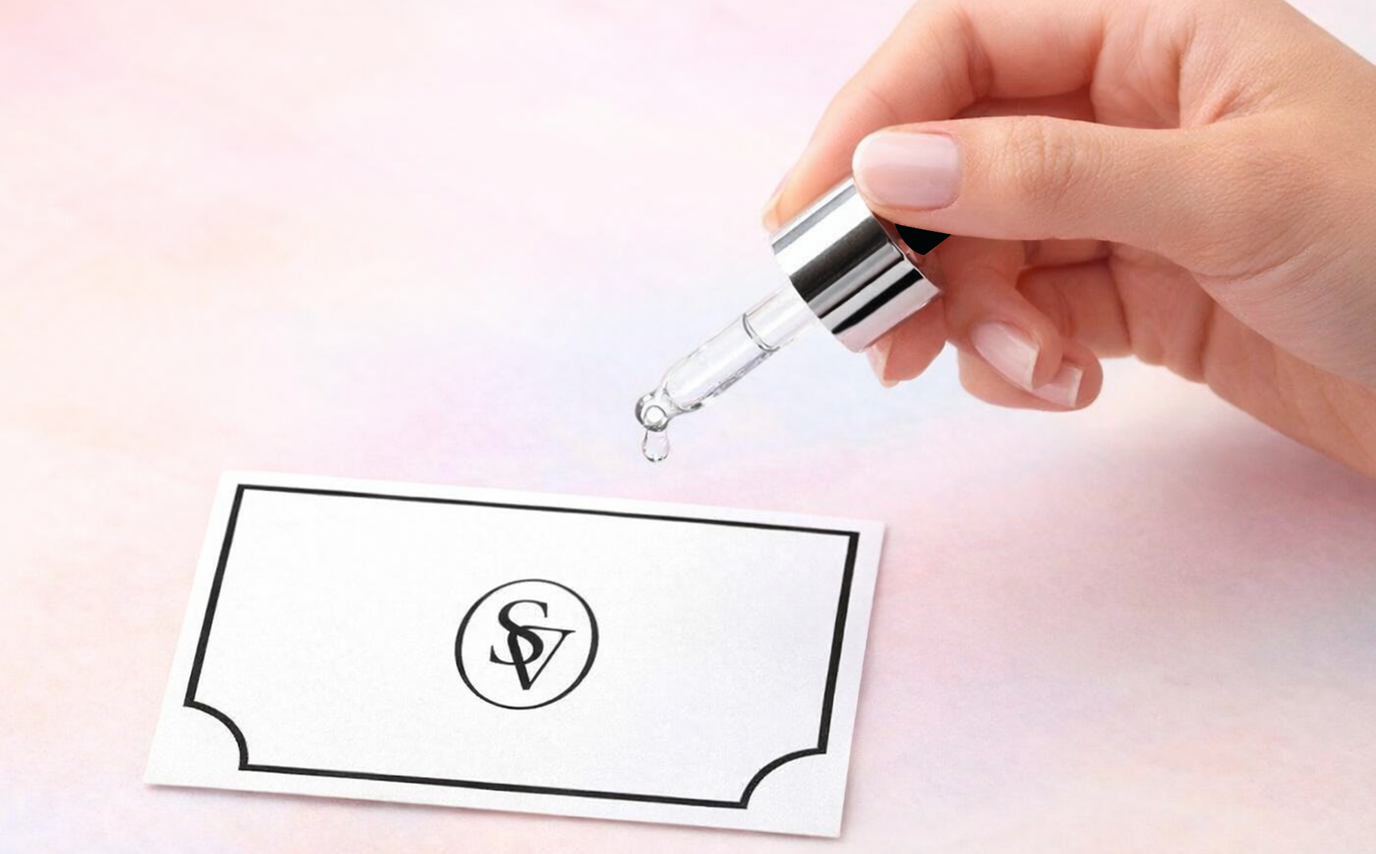 A hand holding a scent dropper and a scent card with light pink background
