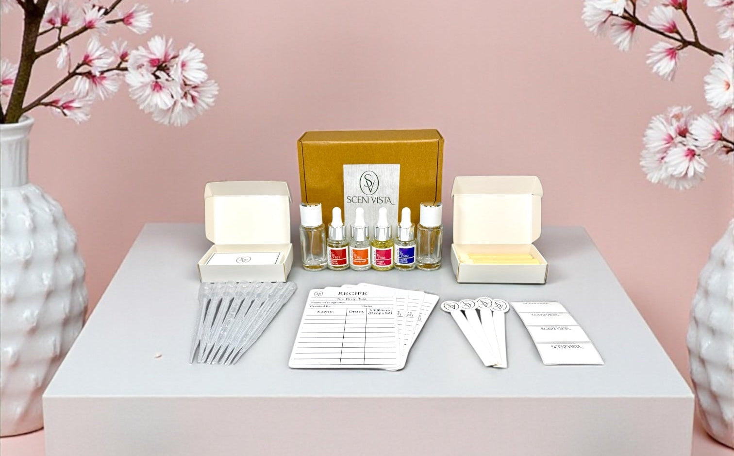 Fragrance set on a table with cherry blossom branches against a pink background