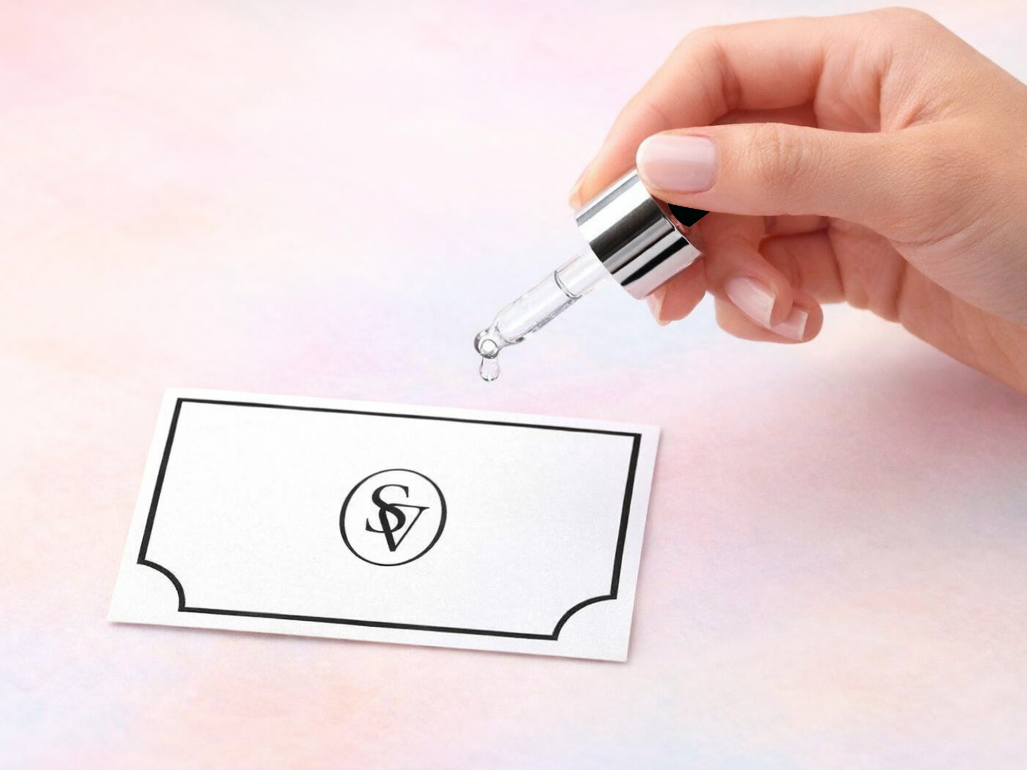 A hand holding a scent dropper and a scent card with light pink background