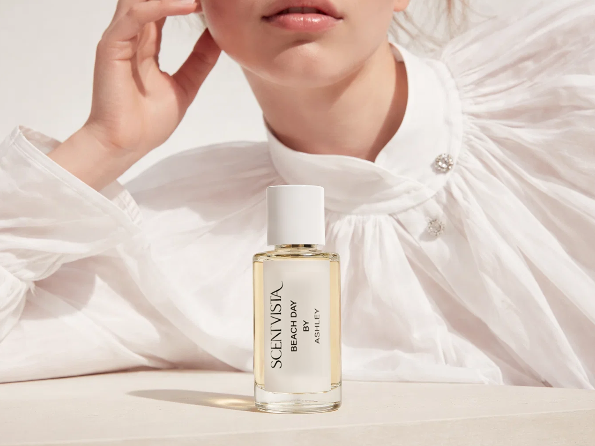 A custom fragrance bottle in front of a woman