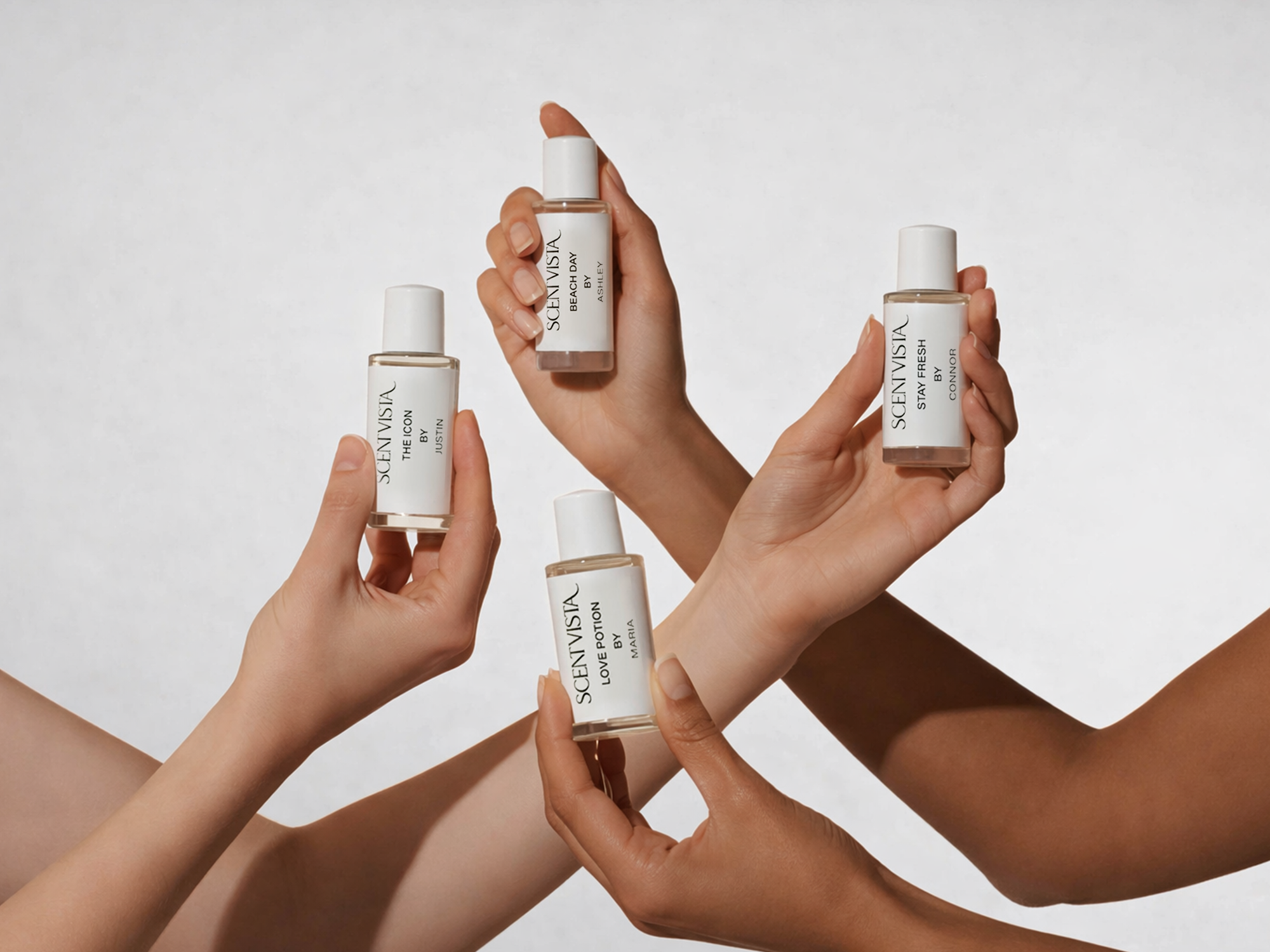 Multiple hands holding custom fragrance bottles with a neutral background